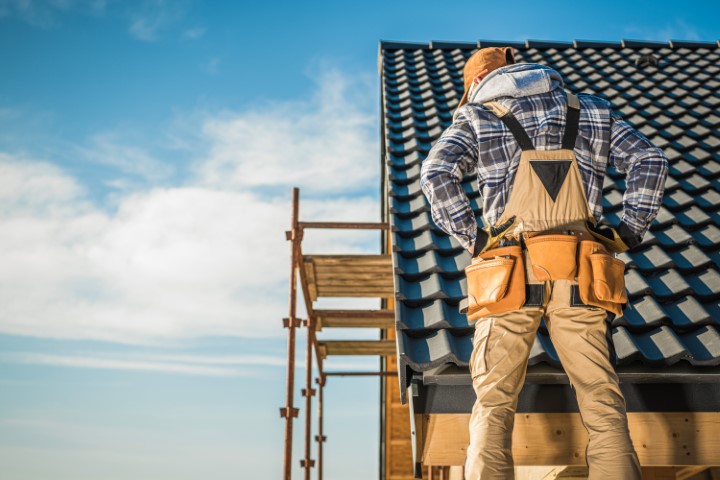 man inspecting roof for tesla solar tile installation